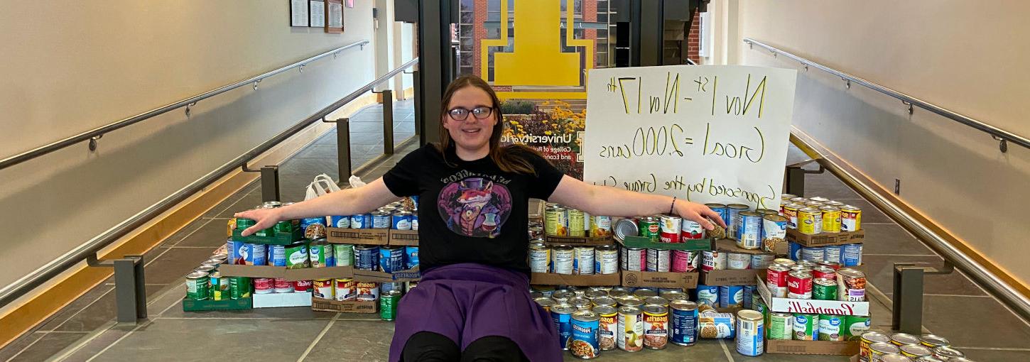 365滚球官网 student, Zoe Evans stacks cans of food she purchased for a donation.