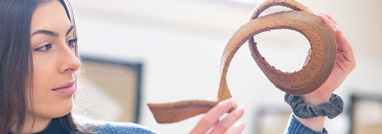 Marissa Hilliard examines a sample of 3D printed wood waste